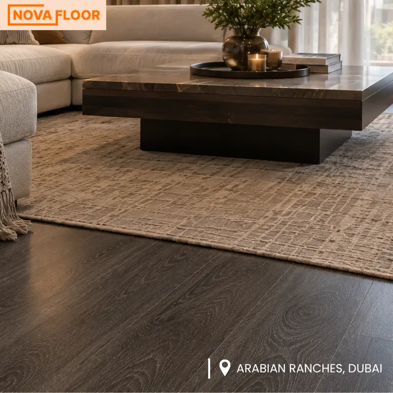 Close-up of dark wood flooring with cream sofa and modern living room décor in Arabian Ranches